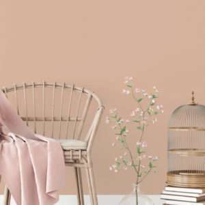 Salon avec fauteuil en rotin et vase de fleurs, mis en valeur par notre brun rosé BRUT ROSÉ - N°1893 Peintures 1825