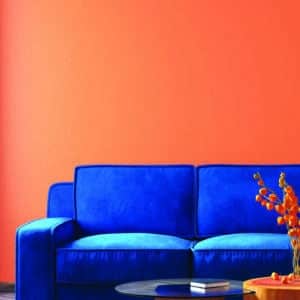 Salon avec canapé en velours bleu, mis en avant par notre orange CORAIL - N°2000 Peintures 1825
