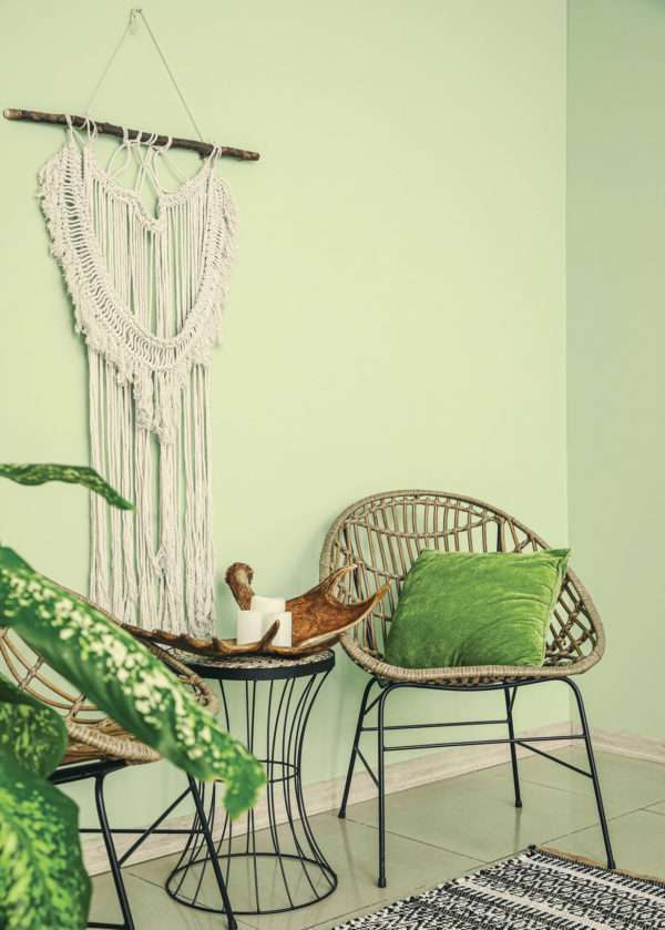 Salon avec fauteuil en rotin et macramé, mis en valeur par notre vert clair LAIT D'AMANDE - N°1959 Peintures 1825