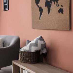 Salon avec carte du monde en liège et fauteuil gris, mis en avant par notre brun rouge OLD LEATHER - N°2039 Peintures 1825