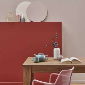 Salle à manger avec table en bois et fauteuil rose, mis en avant par notre rouge profond ROUGE SATÉ - N°2058 Peintures 1825