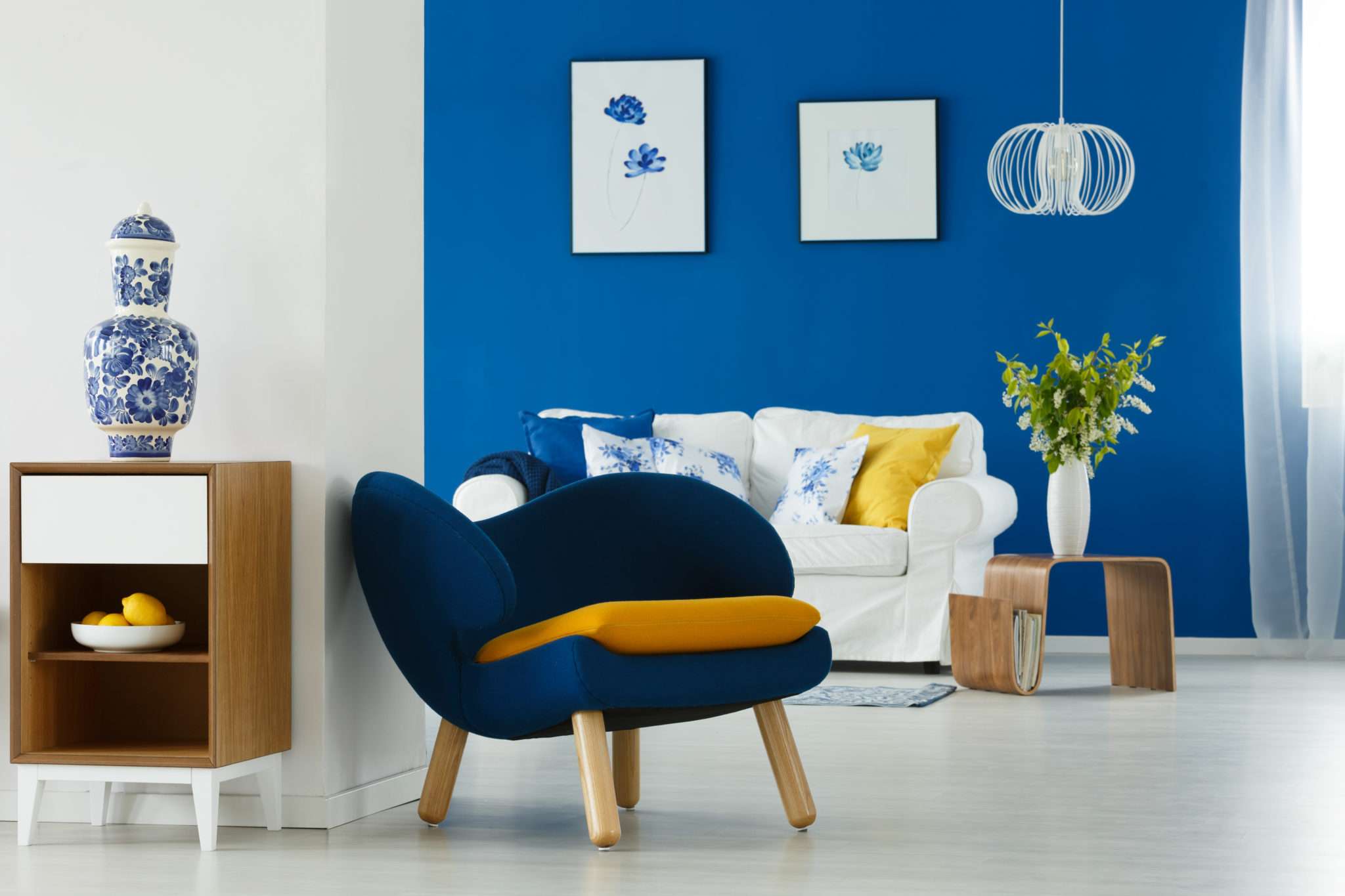 Salon avec canapé blanc et fauteuil en tissu bleu et jaune, mis en valeur par notre bleu vif ELECTRIC BLUE - N°2013