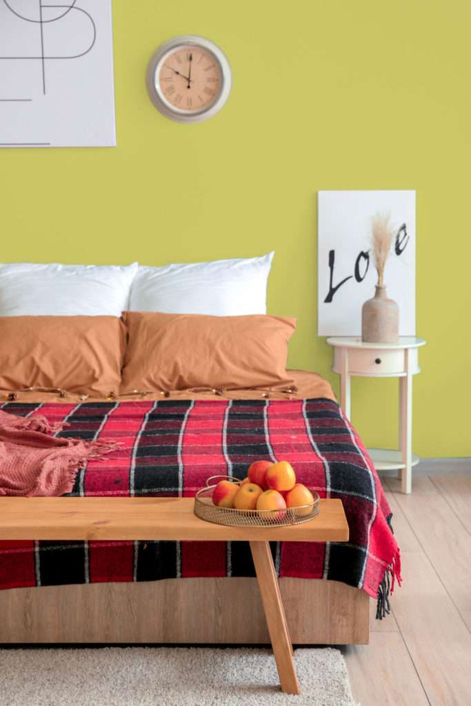 Chambre à coucher avec parure de lit orange, blanche et rouge, mise en valeur par notre vert anis CARAMBOLE - N°2003 Peintures 1825